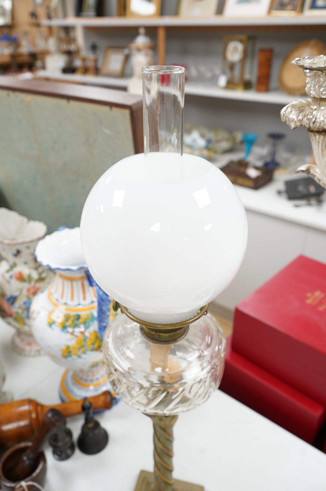 A brass corinthian column oil lamp with glass reservoir and opaque glass shade, 78cm high